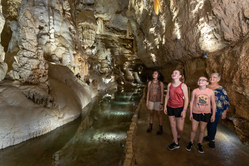 3 Young Ladies and Grandma admiring the cave formations next to a pool of water | Natural Bridge Caverns
