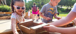 two kids playing with a sluicing tray